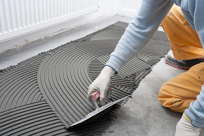 Trải keo dán gạch xuống sàn nhà trước khi lát nền gạch Viglacera